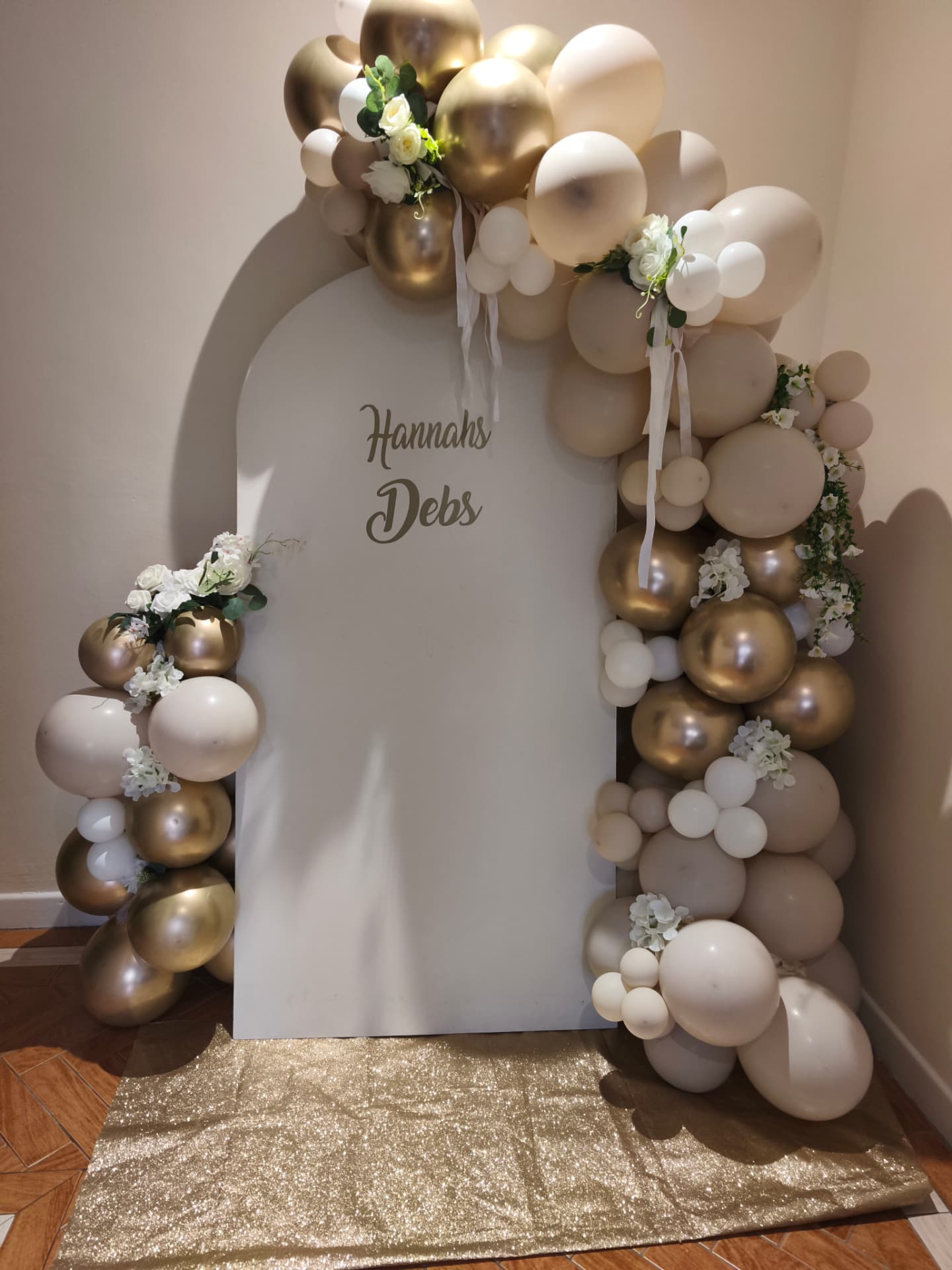 Hannah's Debs — white arch with gold & champagne garland